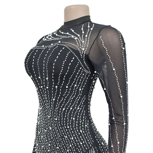Dettaglio maglia in rete nera con perle bianche e strass argentati a raggiera
