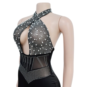Detail of black mesh jumpsuit with pearl and rhinestone patterns on neck and cutout