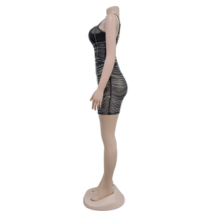 Close-up of black mesh mini dress featuring sparkling rhinestone patterns and spaghetti straps