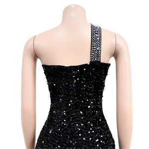 Detail of black sequin evening dress featuring rhinestone shoulder strap and shiny finish