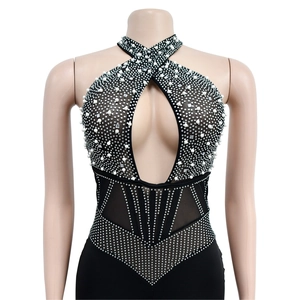 Detailed view of black mesh romper with white pearls and sparkling rhinestone patterns