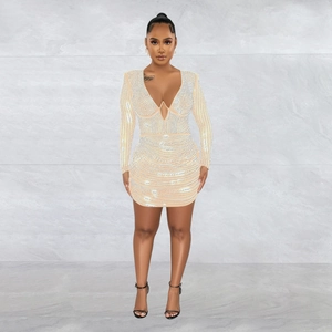Detail of beige bodycon dress featuring shimmering silver rhinestones and deep V-neckline