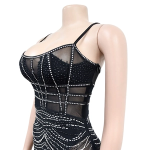 Detail of black mesh party dress featuring intricate silver rhinestones and stud patterns