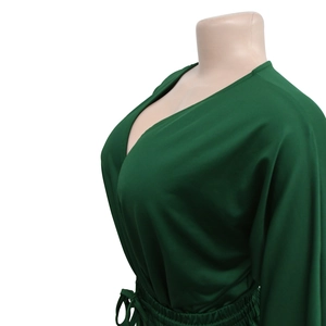 Detail of deep V-neckline and adjustable drawstring waist on a dark green romper