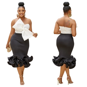 Detail of white strapless bow top and black mermaid skirt with flounced hem