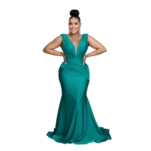 Detail of emerald green satin v-neck evening dress showing pleated waist and fabric texture