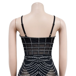 Close-up of sparkling rhinestones and mesh detailing on the back of black mini dress