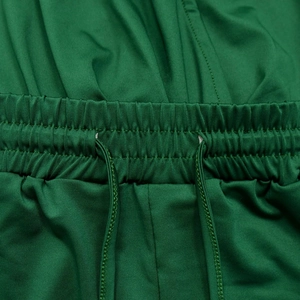 Detailed close-up of the green elastic waistband with a matching drawstring on shorts