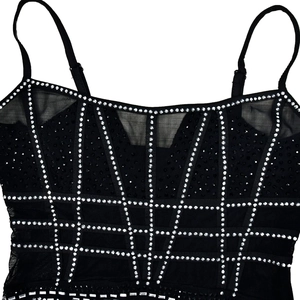 Close-up of black mesh dress featuring intricate silver rhinestones and thin straps