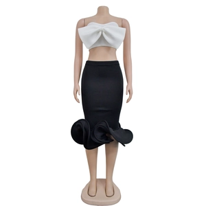 Detailed view of white strapless bow top and black pencil skirt with ruffled hemline