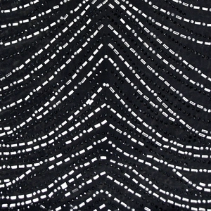 Macro view of black mesh fabric with sparkling white and black rhinestone V-shape pattern