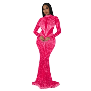 Dettaglio elegante abito da sera magenta con strass scintillanti e maniche lunghe in rete