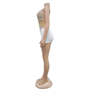 Detail showing the white pearls and rhinestones on skin-tone mesh fabric of the jumpsuit