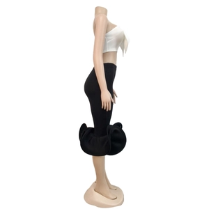 Detail of white tube top and black slim midi skirt with oversized circular ruffles