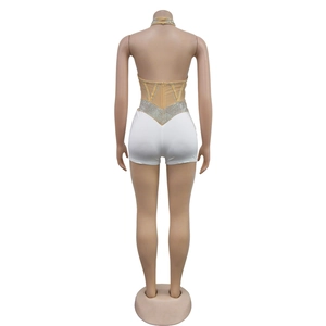 Detailed back view of rhinestone studded mesh top and white V-waist shorts on mannequin