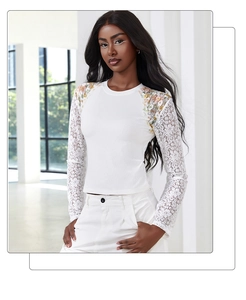 Detail of white long sleeve top featuring floral lace sleeves and colorful shoulder embroidery