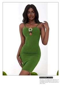 Detail of green bodycon dress featuring chest cutout and sun-shaped metal ornament