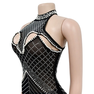 Detail of black mesh halter dress featuring geometric pearl and rhinestone patterns