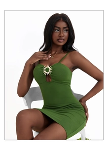 Close-up of green bodycon dress featuring chest cutout with gold sunburst metal ring