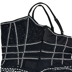 Close-up of black mesh dress with silver rhinestones in a geometric grid pattern