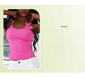 Detail of a rose red ribbed knit crop top with a 3D floral accent on the shoulder strap