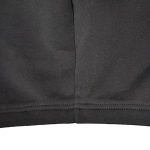 Detailed macro view of double-needle stitching on black fabric hem of a tube top dress