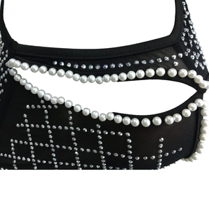 Detail of mesh fabric with pearls and rhinestones on black dress for women