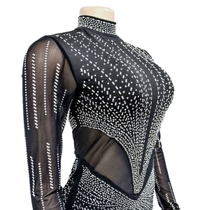 Dettaglio di patchwork in mesh e strass argentati scintillanti su un vestito nero