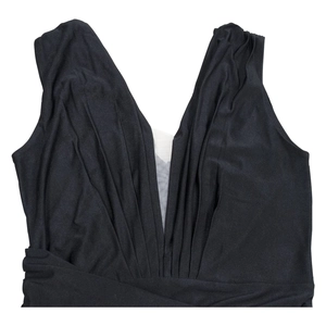 Detail of V-neckline featuring pleated fabric and sheer mesh insert on black sleeveless dress