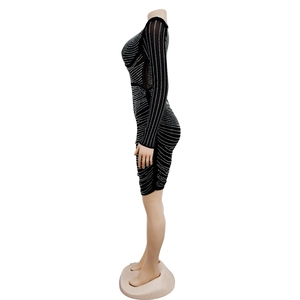 Detailed view of black slim dress with silver rhinestone grid patterns and sheer side mesh