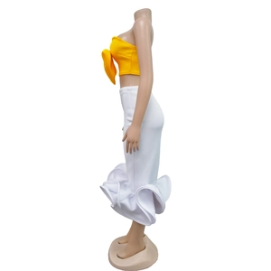 Detail view of yellow bow-knot tube top and white fishtail skirt with ruffled hemline