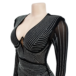 Detail of black rhinestone mesh dress with deep V-neckline and sheer long sleeves