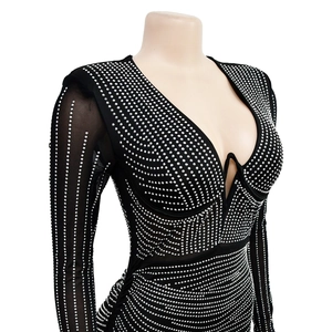 Detail of black mesh sleeves with silver rhinestones and deep V-neckline dress
