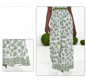 Detail view of the white floral skirt hem with green coral patterns and ruffle trim edge