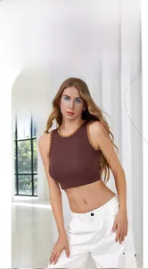 Detail eines dunkelbraunen Rippstrick-Crop-Tops mit orangefarbenen Wellenkante-Details