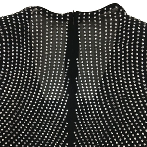 Detail of sheer black mesh fabric with sparkling silver rhinestones and a back hidden zipper