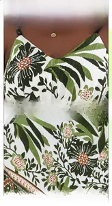 Detail of V-neckline with green bead straps and tropical palm leaf print fabric