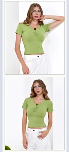 Detail of green V-neck ribbed crop top with front ruching and a brown button accent