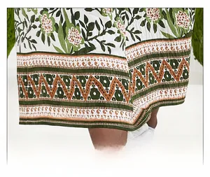 Close-up of bohemian floral print dress hem with green foliage and brown patterns