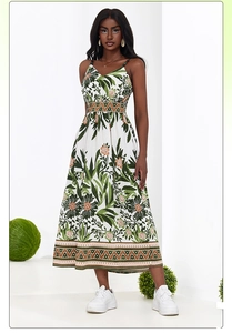 Detail of bohemian summer dress showing green leaf print and orange geometric borders