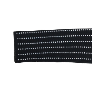 Macro detail of elastic black mesh fabric with six rows of sparkling rhinestones
