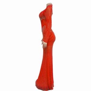Dettaglio dell'abito da sera rosso in rete con strass argentati e orlo lungo ed elegante