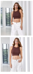 Detail eines braunen Rippstrick-Crop-Tops mit orangefarbenem Wellenrand und Cargohose