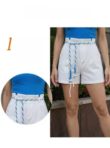 Detail of white linen shorts with high elastic waist and blue braided rope belt decor