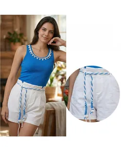 Detail view of white linen cotton shorts featuring a blue and white braided rope belt