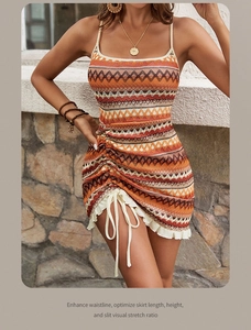 Detail of bohemian knit dress featuring orange stripes, drawstring side and ruffle hem