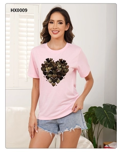 Detail of pink crew neck T-shirt featuring a textured heart pattern with denim shorts
