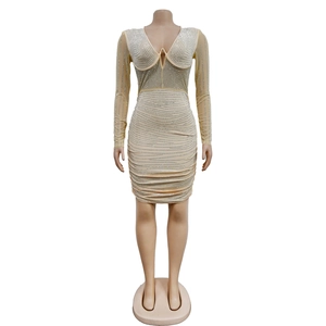 Detail of champagne mesh dress featuring wave-patterned rhinestones and deep V-neckline