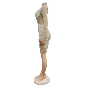 Detail of nude mesh bodycon dress featuring sparkling rhinestones and side ruching