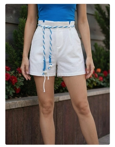 Detailed view of high-waisted white linen shorts with blue and white braided rope belt